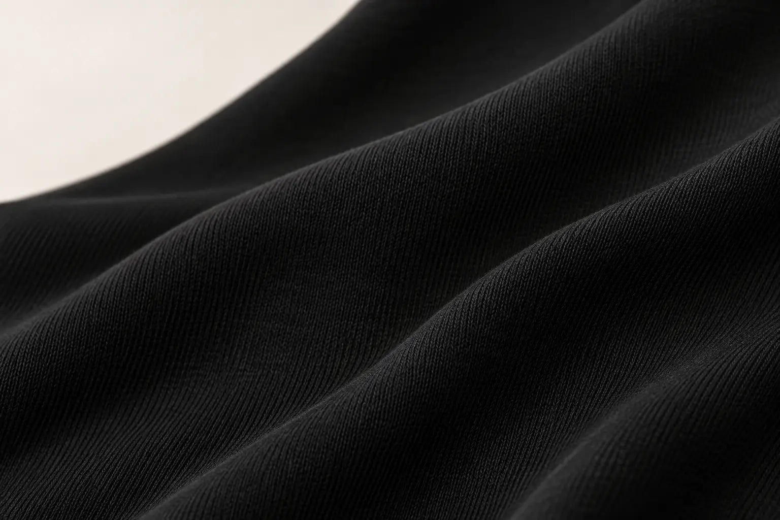 Soft folds of black modal-spandex knit, shown in close-up