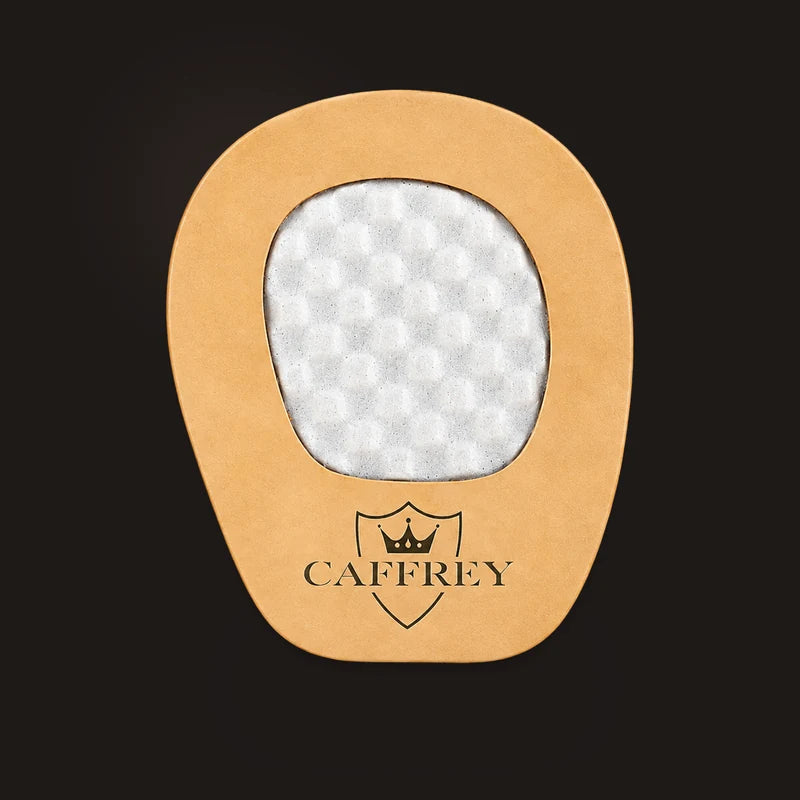 Illustration: Crema Cortona pad, tan leather border around a pale textured centre, CAFFREY crest at the narrow end