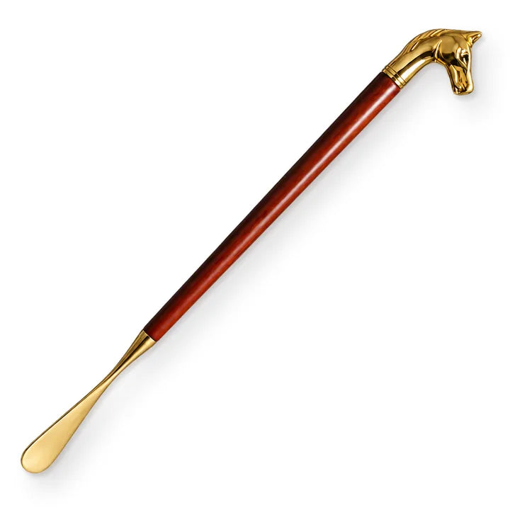 Illustration of the Royal Touch shoe horn laid on a diagonal, gold-tone horse head at the top right