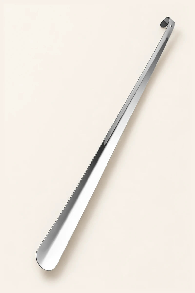 Illustration of a long CAFFREY stainless steel shoe horn with a rounded blade and curled end