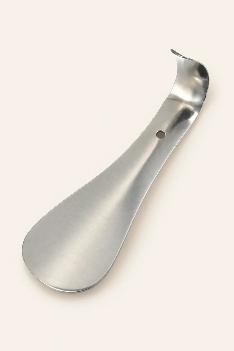 Illustration of a short CAFFREY stainless steel shoe horn with a rounded blade, curled end and small hole