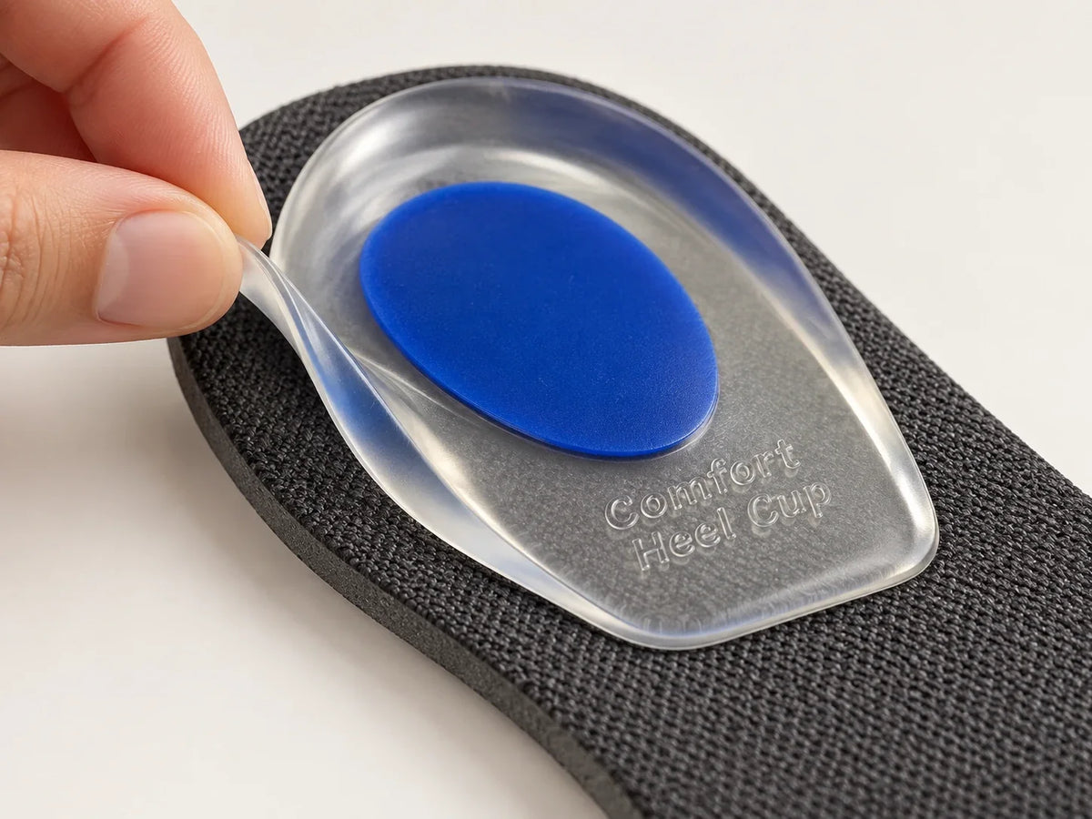 Detail illustration of a hand lifting the flexible clear edge of a blue gel heel pad from an existing shoe insole