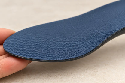 Close view of Step Aid navy fabric and the thin attached dark edge, gently curved over fingertips