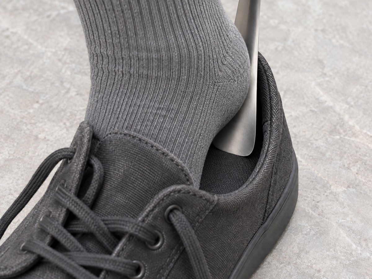 Use illustration: a grey-socked heel slides along the steel blade inside the same charcoal canvas shoe