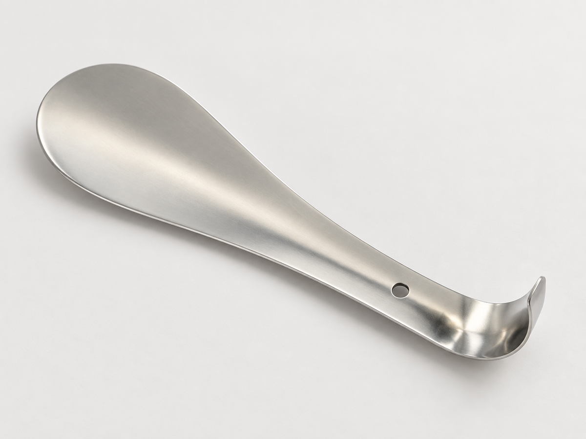 Compact stainless steel shoe horn showing its shallow curved blade and rounded tip