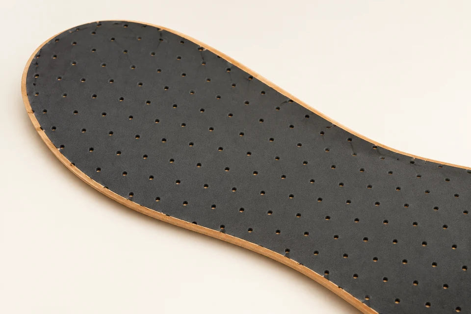 Close detail of Eleganza's smooth perforated charcoal underside and thin tan leather edge