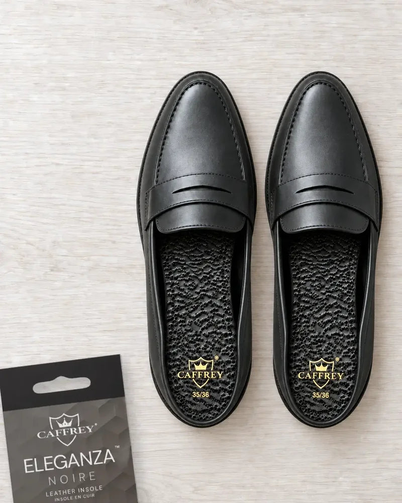 Black leather loafers with Eleganza Noire insoles and gold CAFFREY crests visible at the heels