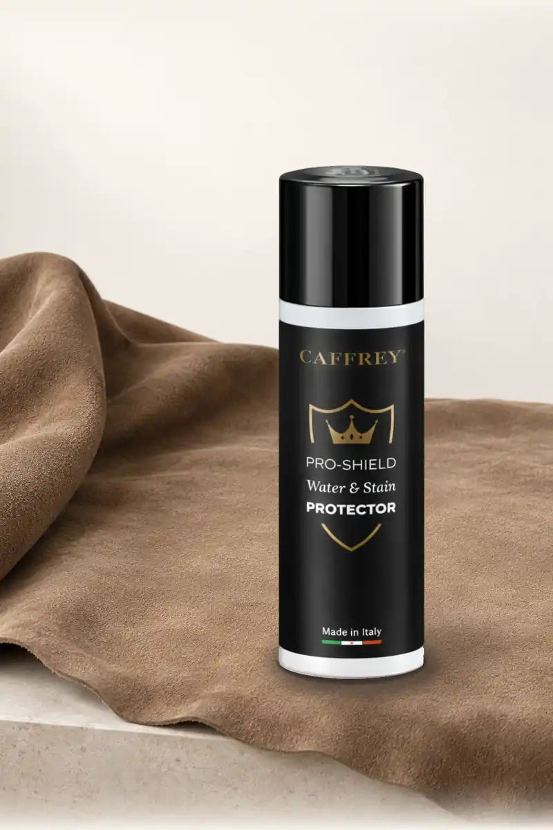 CAFFREY Pro-Shield spray can standing on a piece of tan suede in soft window light