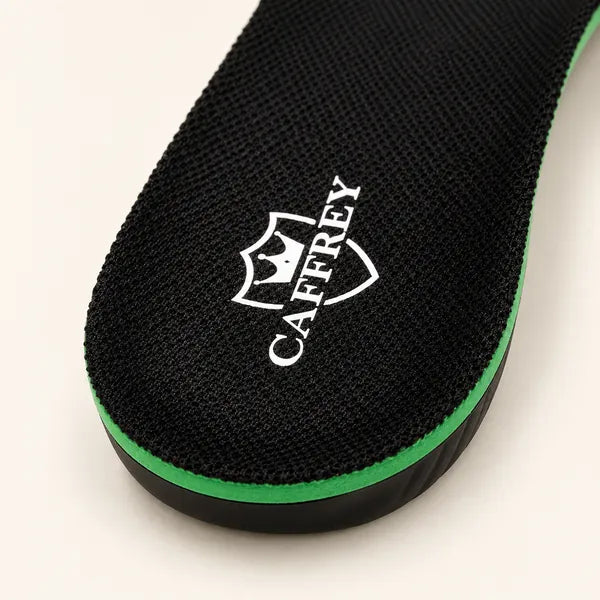Studio close-up of the black knit top of a Walk On Air insole with the white CAFFREY crest at the heel